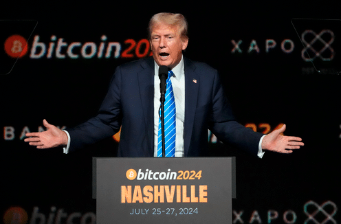 Man in a suit gestures while speaking at a Bitcoin conference in Nashville, July 2024.